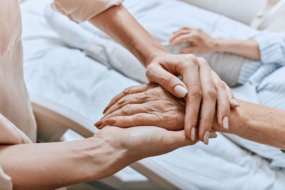 An image showcasing hospice care, how a lady cares for the elderly person