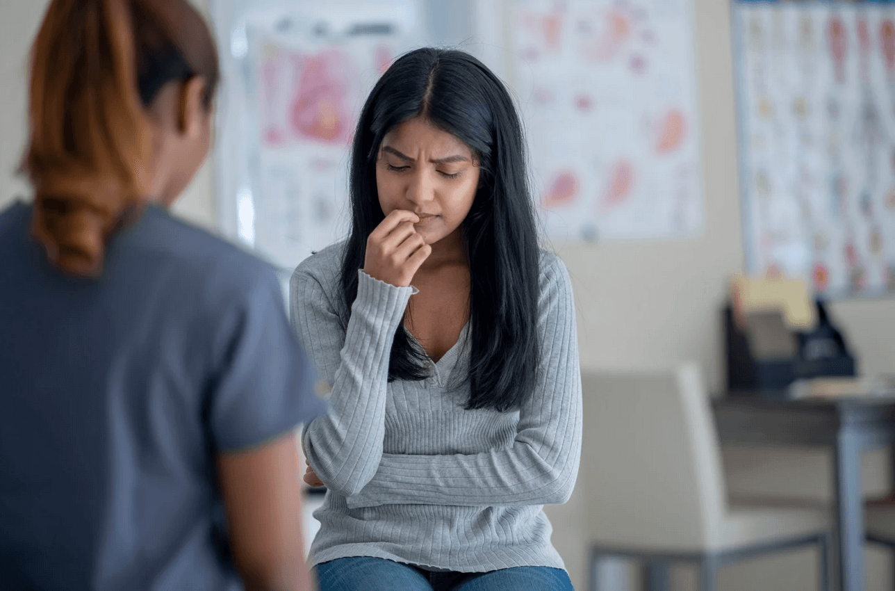 An image of Psycho-social interventions. There are 2 women in the image, one is a teenager and one is an older woman. The older woman is having a conversation with the teenager.