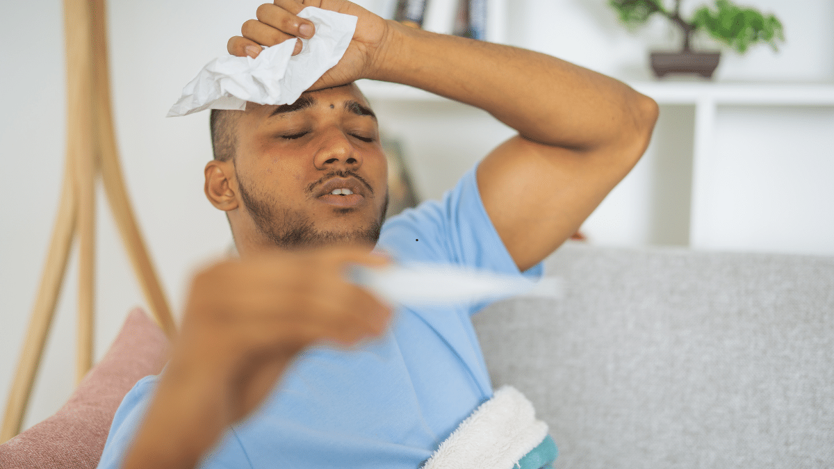 image of anguished man looking at a thermometer